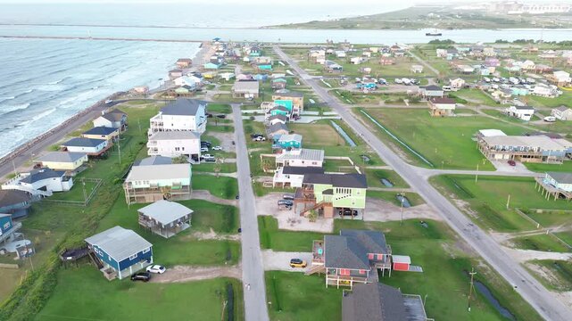 Jetty shoreline grid shows homes west of Seashell Dr positioned near Surfside Beach breakwater long jetty extending into Gulf. Bright siding, clean rooflines over elevated blocks in Freeport, TX