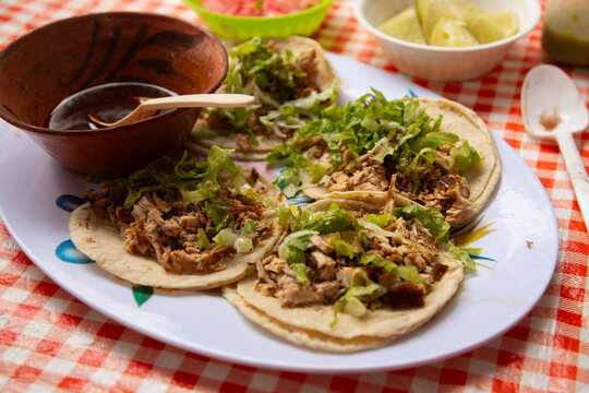 Close-up of tender, roasted cochito horneado served on tacos with fresh parsley garnish in Chiapas del Corzo, Mexico.
