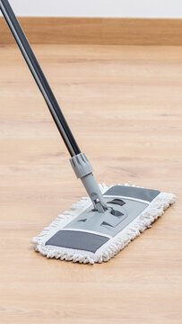 Closeup of a young woman mopping the office floor