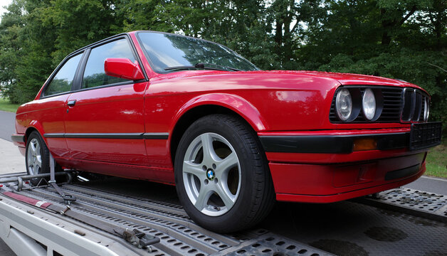 Hamburg, Germany - Aug 25 2024 Red BMW 3-series, E30 two-door saloon, on a car transporter