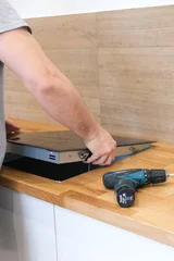 Technician Carefully Positions Oven Within Surface Opening. Skilled Worker Utilizes Tools To Install Oven Precisely And Safely © Evgeniia Biriukova