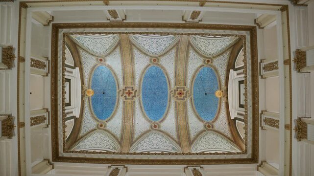 Ornate historic ceiling of Macy's on State Street department store in Chicago featuring intricate moldings, gold detailing, elegant blue mosaic artwork