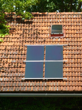 Old Bavarian tiled roof with solar photovoltaic panels, detail