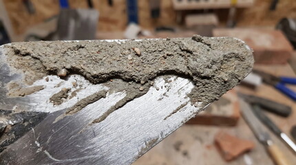 Fototapeta premium Trowel covered with fresh cement mortar for bricklaying work