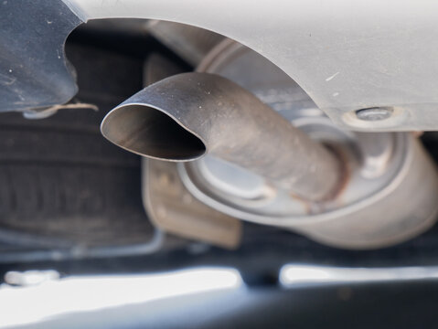 automobile tailpipe and muffler assembly system under a car. Ideal for automotive repair, vehicle maintenance, environmental emissions, and transportation industry concepts