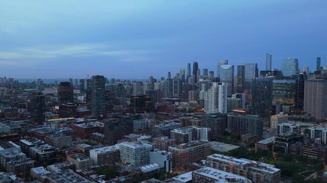 Chicago cityscape showing downtown district financial towers and urban residential area, early morning glow illuminates modern buildings against blue sky