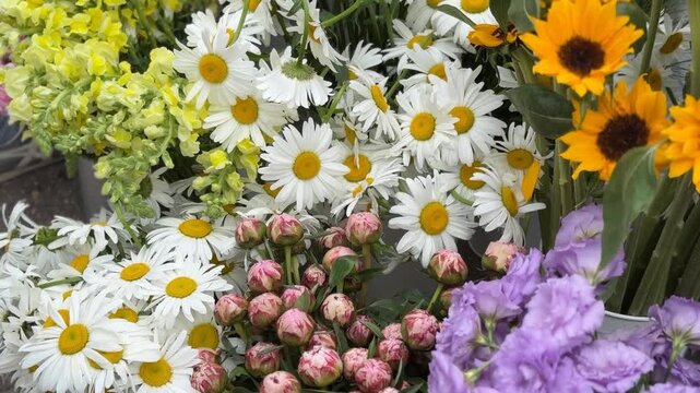 Colorful assortment of daisies, peonies, sunflowers, and lisianthus in florist shop display