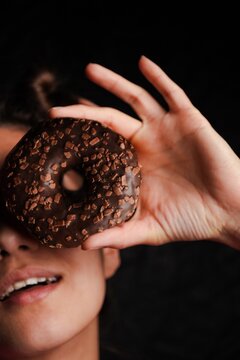 Person holding donut over eye creative concept