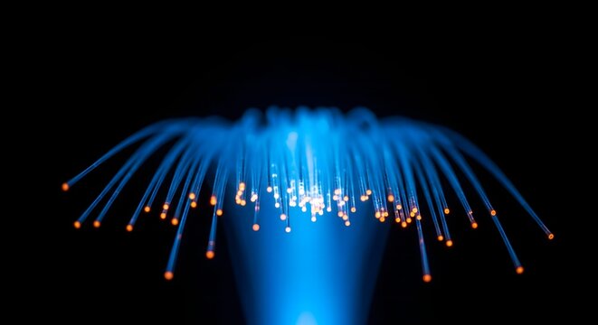 Close up of blue glowing fiber optic cables used for high speed data transmission against a dark background