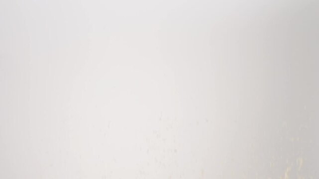 Crunchy Bread Crumbs raining down on a white backdrop in slow motion close up macro.