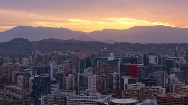 Sunset on a cloudy autumn day, with residential and office buildings, in the Las Condes commune, with the coastal mountain range in the background, in the city of Santiago, Metropolitan Region, countr