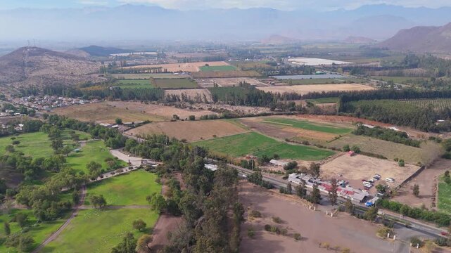 Green hectares with agriculture and giant trees, with an avenue that crosses the plantations, next to the temple of the Andes, in the Andes, Valparaiso region, country of Chile
