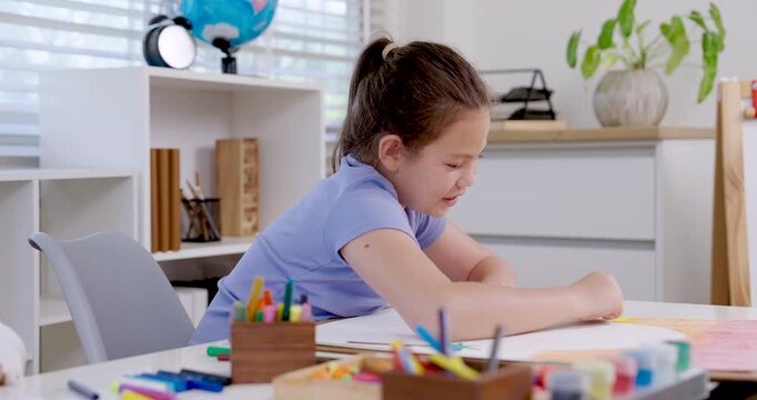 caucasian girl preteen student concentrating on drawing with colored pencil during slowmotion classroom art lesson sitting at desk creativity learning education childhood study achievement moment