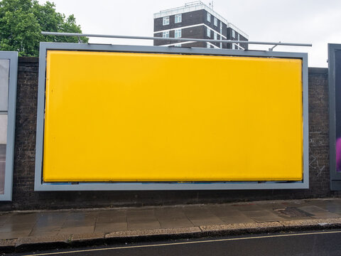 LONDON - blank yellow advertising hoarding on brick wall