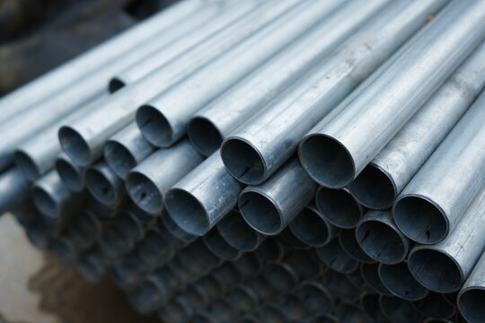 Stack of galvanized steel pipes arranged in rows at construction site storage area