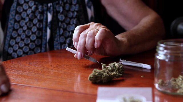 Elderly woman preparing medical marijuana joint