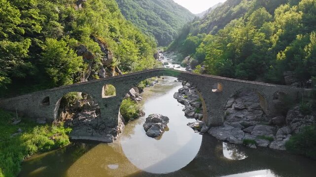 Devil Bridge ancient stone arch Arda river gorge Bulgaria aerial drone slow motion medieval landmark Rhodopes travel tourism green canyon Ardino heritage
