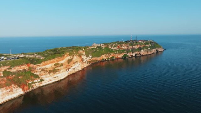 Cape Kaliakra rocky cliff aerial drone Black Sea Bulgaria red stone promontory ruins lighthouse slow motion nature travel tourism coastline landmark Dobrich region
