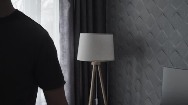Man Turning Off Floor Lamp in Modern Cozy Room