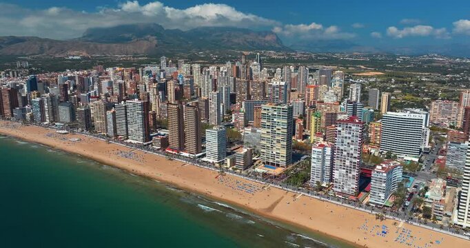 Benidorm aerial panorama beach highrise skyline Alicante mountains background Costa Blanca Spain slow motion summer drone tourism Mediterranean real estate travel resort