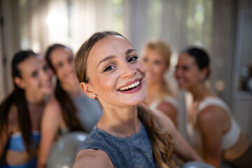 Obraz premium Group of cheerful women taking fitness class selfie