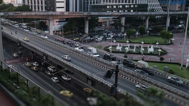 Timelapse, overview interval shooting in a large metropolis. A lot of cars are moving along highways, rush hour, trains are moving along the monorail, people are moving through the city park area