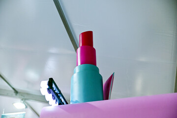 A giant, decorative oversized lipstick sculpture in pink and red shades used as a creative prop or store fixture © awgraphoto