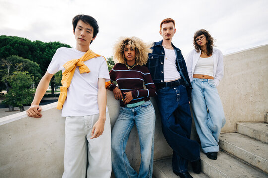 Young diverse friends posing casually outdoors on steps