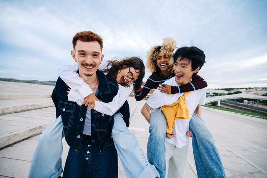 Friends laughing on piggyback outdoors