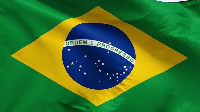 Waving Brazilian flag with green yellow diamond and blue circle with stars and motto Ordem e Progresso