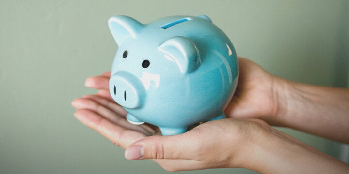 Financial stability and planning with hands holding a blue piggy bank