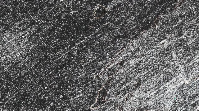 Gray textured surface with diagonal streaks, dense grain, and rough weathered appearance throughout. Grunge texture background animation.