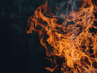 Fototapeta premium Macro detail of dancing orange fire flames against dark moody background with smoke wisps.