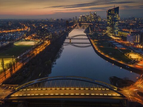The lights of the European Central Bank (ECB) and the Frankfurt banking skyline glow in the evening. (Aerial view with a drone), Osthafen, Frankfurt am Main, Hesse, Germany