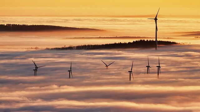 Forest and wind turbines rise from cloud cover, wind farm, silhouettes at sunset, dense sea of fog in the valley, inversion weather, K&ouml;terberg, L&uuml;gde, Weser Hills, North Rhine-Westphalia, Germany
