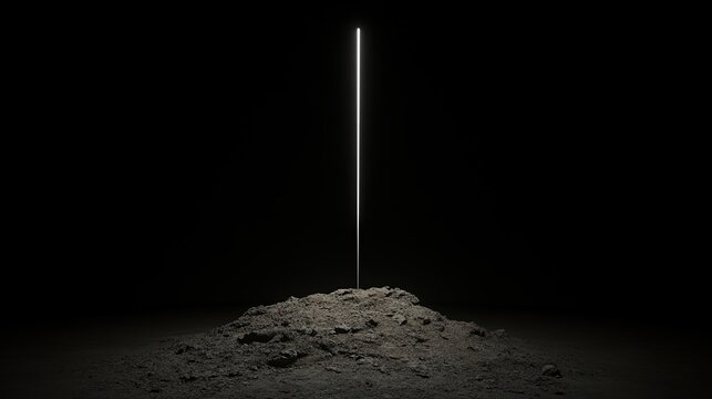 A solitary metal rod stands upright from a rough dirt mound against a black backdrop