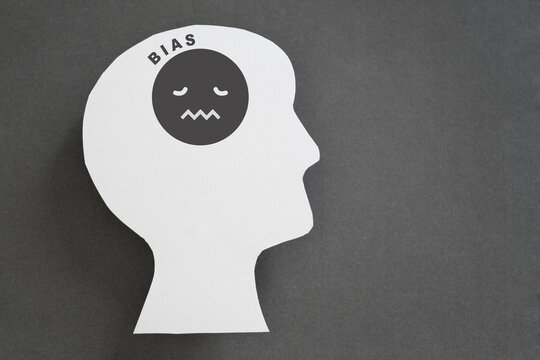 human head real white paper cut with unhappy face icon and bias text on grey background