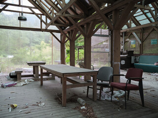 Fototapeta premium Abandoned Cafe Interior With Dusty Tables, Chairs, and Scattered Trash 