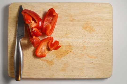 chopped red bell pepper and silver knife against wooden chopping board with generous copy space, red pepper culinary overlay, pepper photo for branding