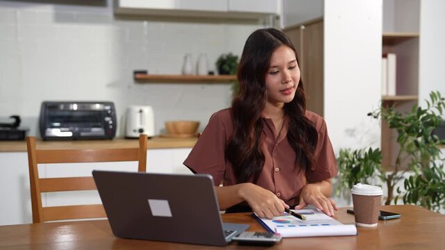 Lifestyle people, using computer working online, doing searching, sitting in the kitchen. Happy woman, entrepreneur, small business owner working online at home office.