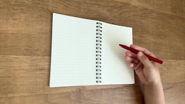 Child Hand Picking Up Red Pen to Write in Notebook, 4K