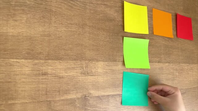 Child Hands Placing Fifth Small Origami Paper in Grid, 4K