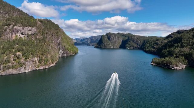 RIB tourists crossing Osterfjorden toward Modalen on sunny spring day in western Norway