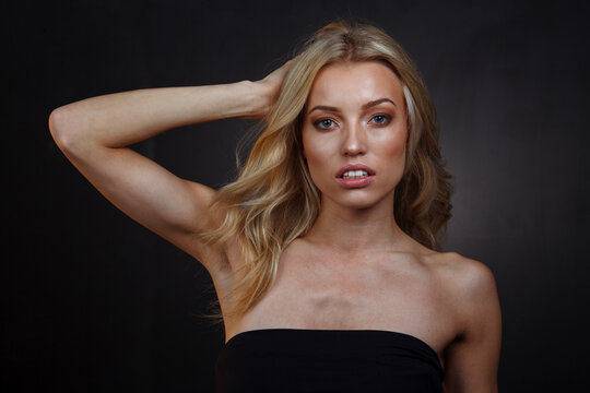 Intoxicating Blonde Allure: Blue-Green Eyes and Hair Touch on Dark Stage