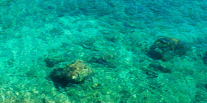 Crystal clear turquoise water with submerged rocks