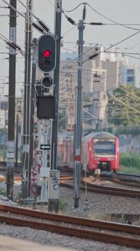 Train approaching intersection with traffic signals in the city during daylight hours