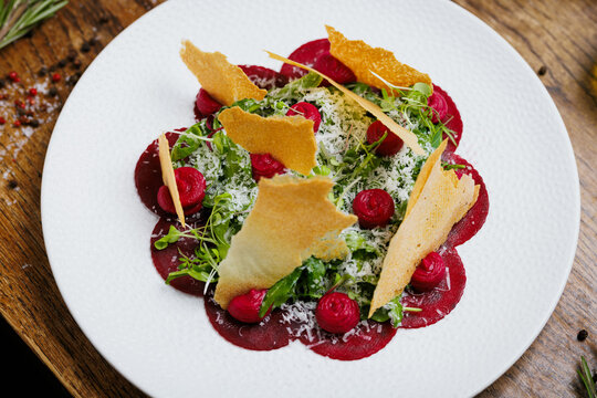 Beetroot salad with parmesan and herbs on wooden table