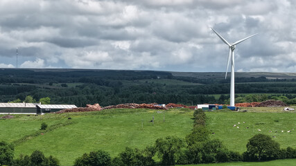 Fototapeta premium Wind turbine generating clean energy on rural farm landscape.