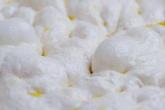 Naturally fermented sourdough focaccia dough during the final proofing stage. The dough surface is filled with air bubbles artisan bread-making process and traditional natural leavening techniques.