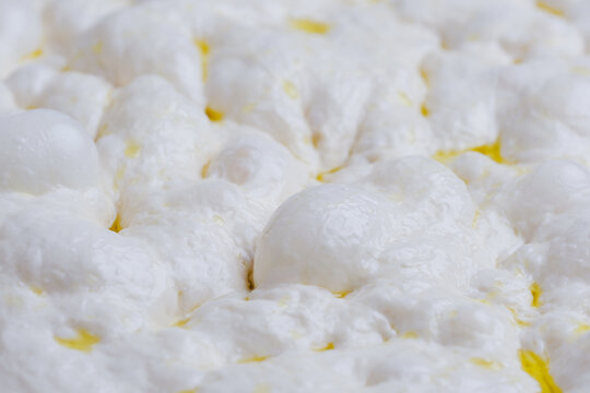 Naturally fermented sourdough focaccia dough during the final proofing stage. The dough surface is filled with air bubbles artisan bread-making process and traditional natural leavening techniques.